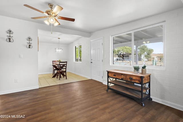 entrance foyer featuring vaulted ceiling with beams, ceiling fan, hardwood / wood-style floors, and brick wall