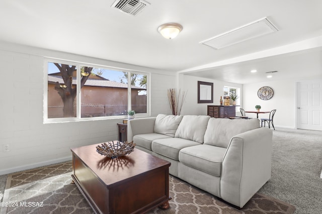 carpeted living room with brick wall