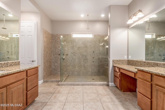 bathroom featuring tile patterned flooring, recessed lighting, two vanities, and a shower stall