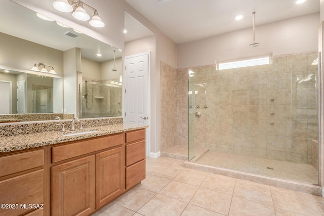 full bath featuring vanity, tile patterned flooring, a stall shower, and visible vents