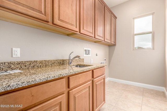 laundry area with cabinet space, washer hookup, baseboards, and a sink