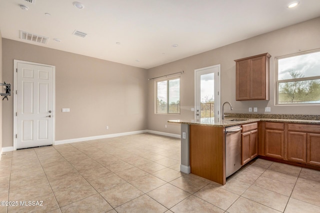 kitchen with stainless steel dishwasher, light stone countertops, brown cabinets, and visible vents