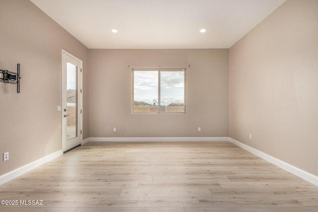 empty room featuring baseboards, recessed lighting, and light wood-style flooring