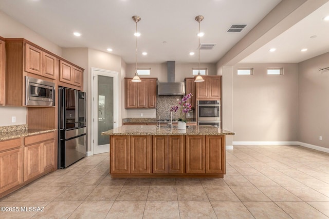 kitchen with light stone counters, visible vents, appliances with stainless steel finishes, and wall chimney exhaust hood