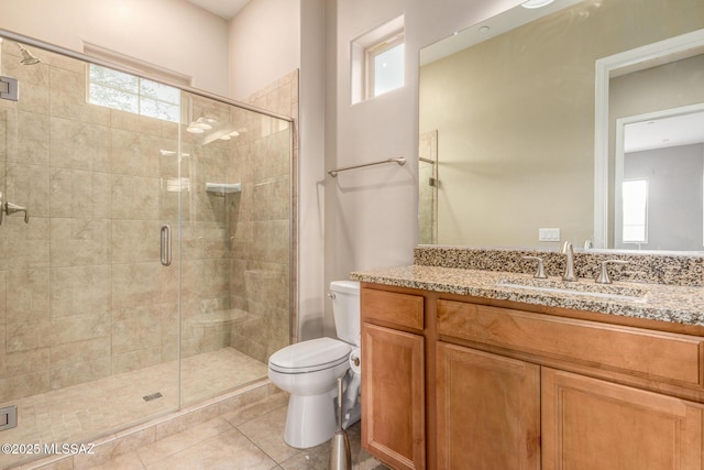 bathroom with toilet, tile patterned floors, a shower stall, and vanity
