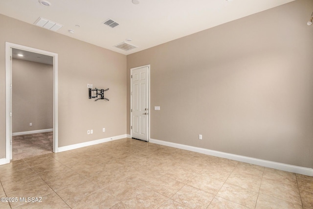 empty room with visible vents, baseboards, and light tile patterned flooring