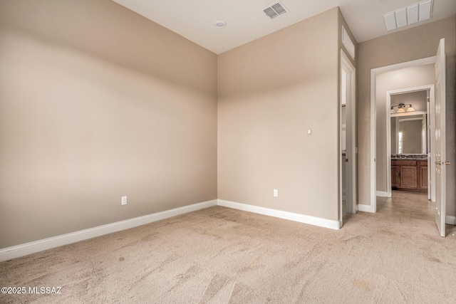 unfurnished room featuring visible vents, baseboards, and light carpet