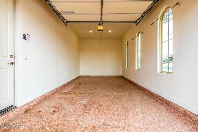 garage with baseboards, a garage door opener, and recessed lighting