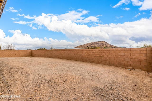 view of yard with a fenced backyard and a mountain view