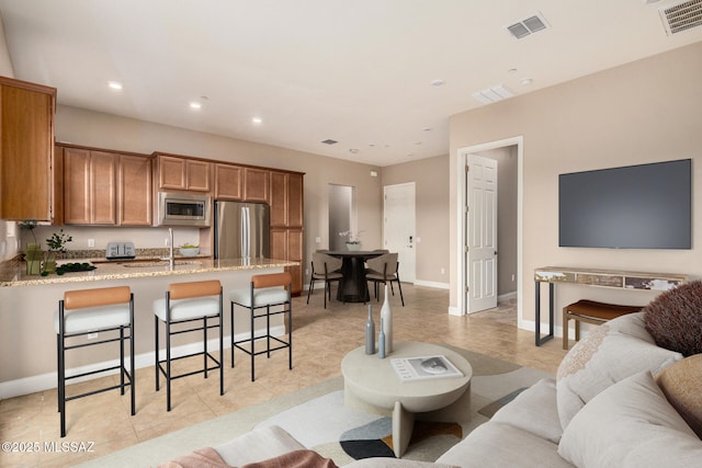 living area with visible vents, recessed lighting, and baseboards