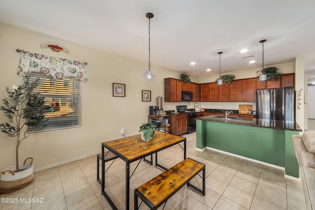 kitchen with sink, light tile patterned floors, black appliances, and decorative light fixtures