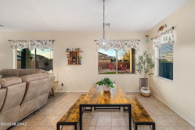 dining space featuring light tile patterned floors and a chandelier