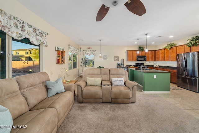 living room featuring ceiling fan, sink, and light tile patterned floors