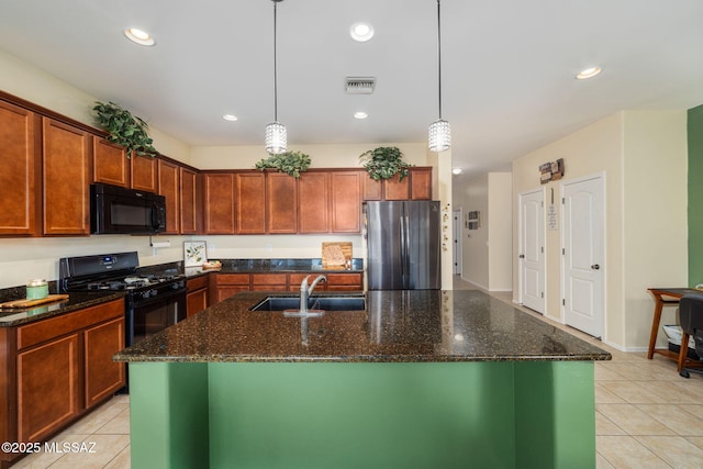 kitchen with black appliances, decorative light fixtures, a center island with sink, and sink