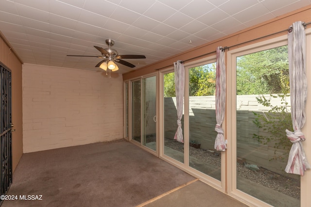 unfurnished sunroom with ceiling fan