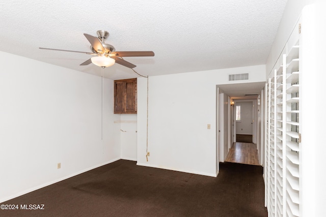 unfurnished room featuring ceiling fan, a textured ceiling, and dark colored carpet