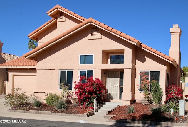 view of front facade with a garage, a chimney, and stucco siding