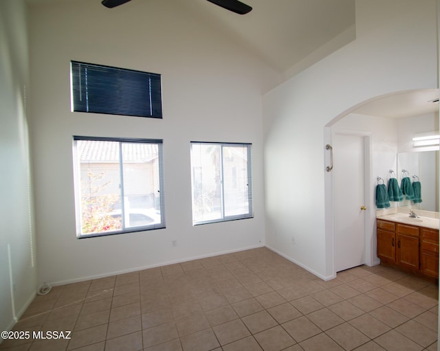 spare room with high vaulted ceiling, a ceiling fan, arched walkways, and a sink