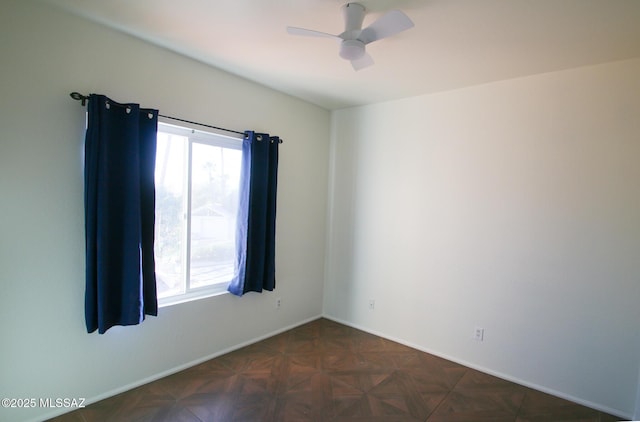 empty room with plenty of natural light, baseboards, and a ceiling fan