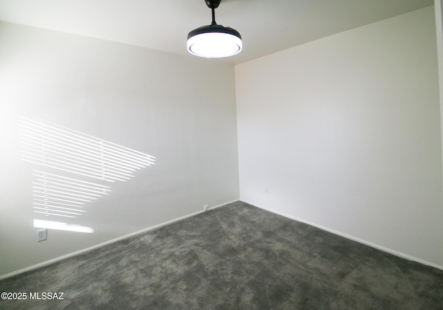 empty room with baseboards and dark colored carpet