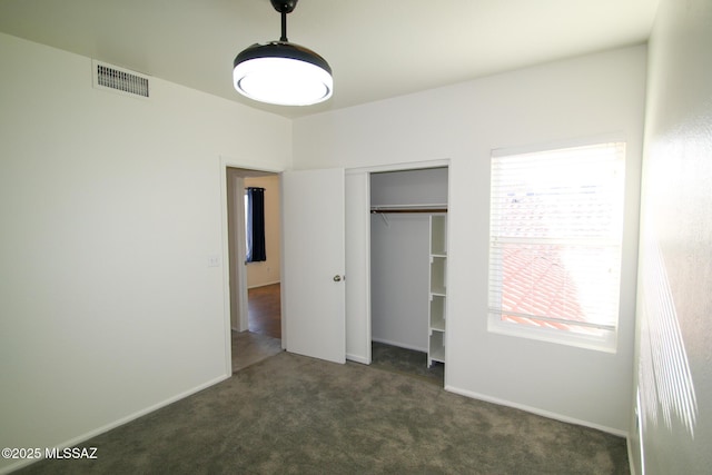 unfurnished bedroom featuring baseboards, carpet, visible vents, and a closet