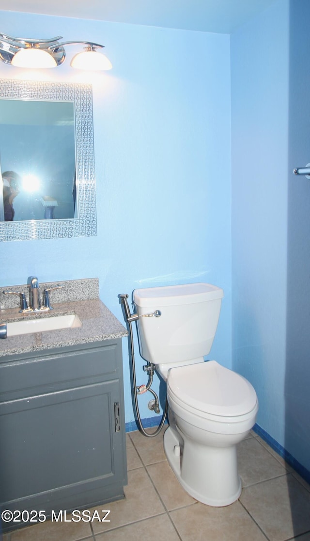 bathroom with tile patterned flooring, vanity, and toilet