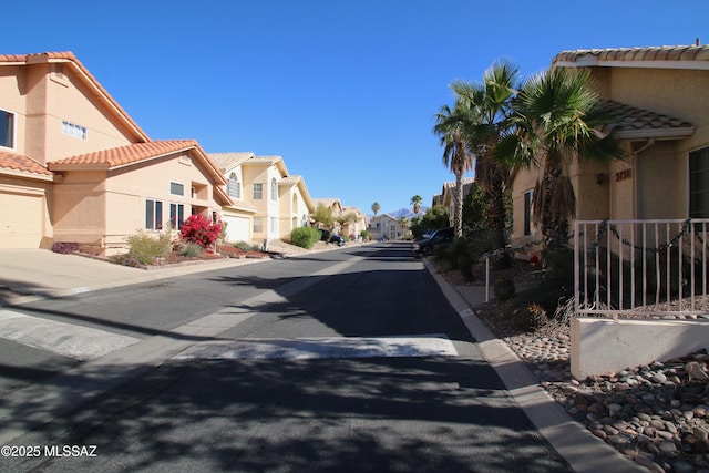 view of road featuring a residential view and curbs