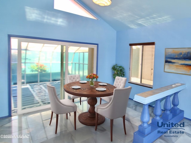 dining space featuring tile patterned flooring and lofted ceiling