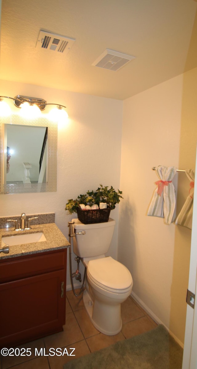 half bath with toilet, vanity, visible vents, and tile patterned floors