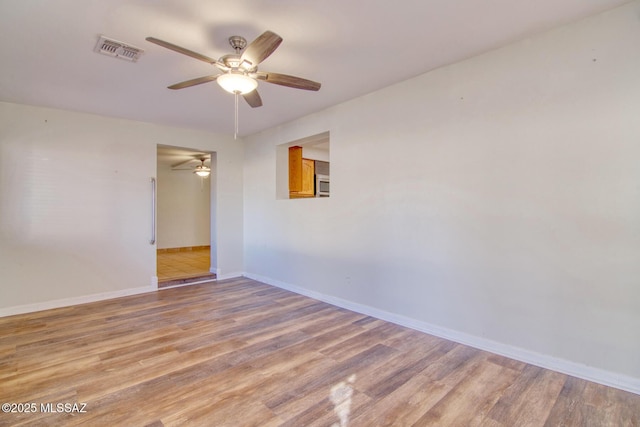 empty room featuring ceiling fan and light hardwood / wood-style floors