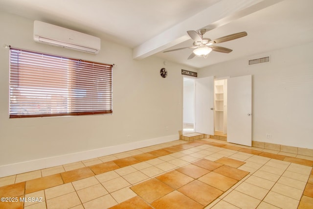 spare room with a wall unit AC, ceiling fan, beamed ceiling, and light tile patterned flooring