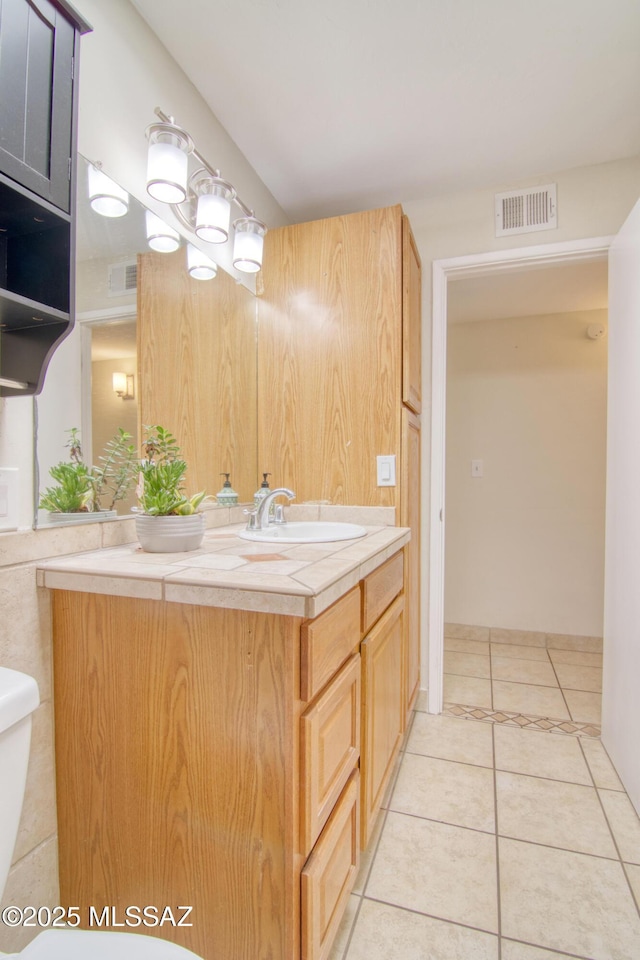 bathroom with tile patterned floors, vanity, and toilet