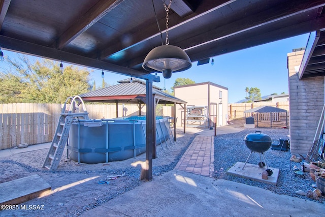 view of patio / terrace featuring a fenced in pool and a gazebo