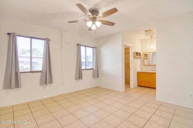 unfurnished room featuring ceiling fan, a healthy amount of sunlight, and light tile patterned floors