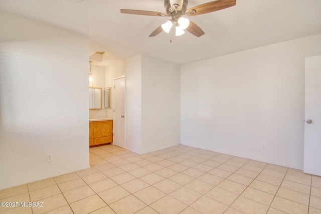 tiled spare room featuring ceiling fan