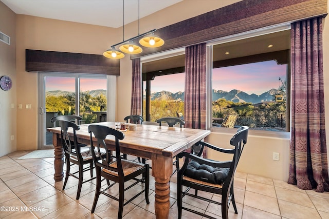 dining area with a mountain view and light tile patterned floors