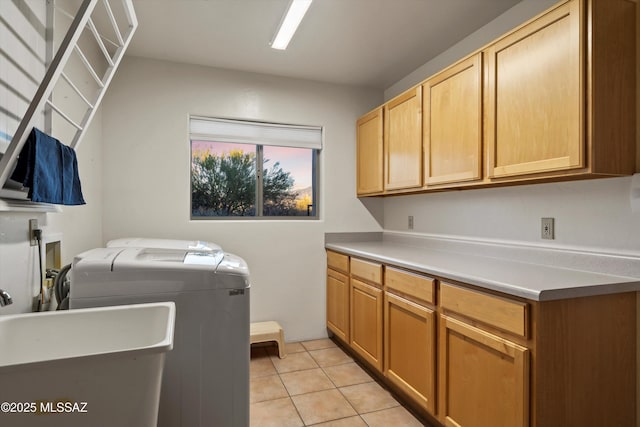 washroom with sink, light tile patterned flooring, cabinets, and independent washer and dryer