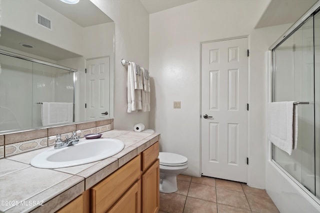 full bathroom featuring toilet, combined bath / shower with glass door, decorative backsplash, tile patterned floors, and vanity