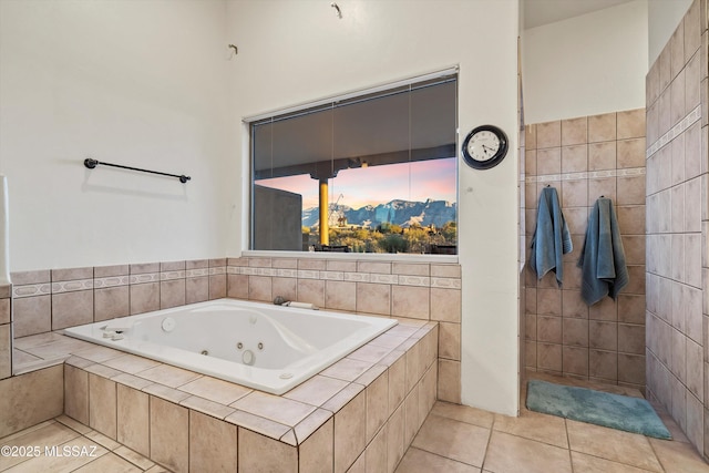 bathroom with tiled tub and tile patterned floors