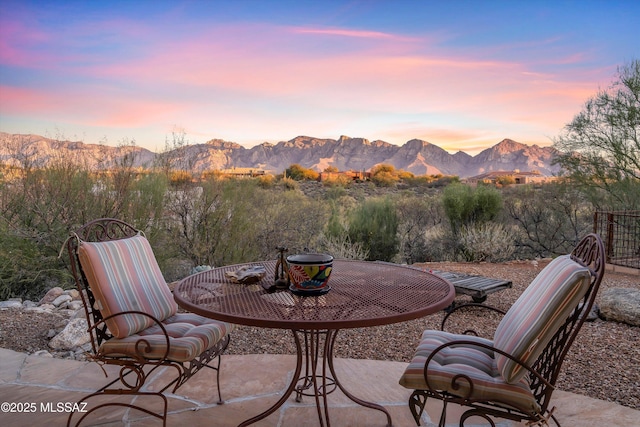 patio terrace at dusk featuring a mountain view