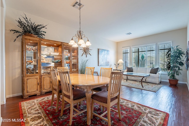 dining room featuring dark hardwood / wood-style flooring and a chandelier