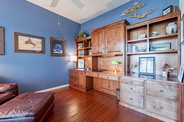 office space featuring ceiling fan, built in desk, and dark wood-type flooring