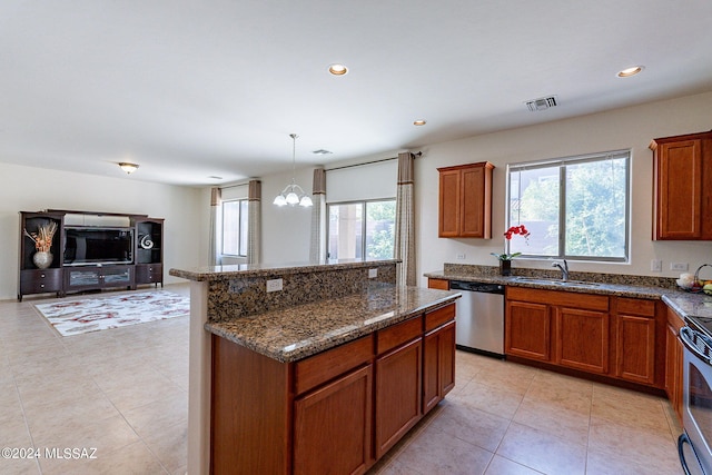 kitchen with sink, stainless steel dishwasher, a notable chandelier, dark stone countertops, and decorative light fixtures