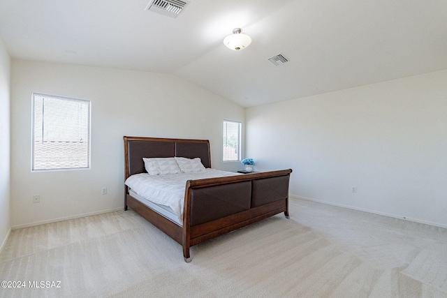 bedroom featuring lofted ceiling and light carpet