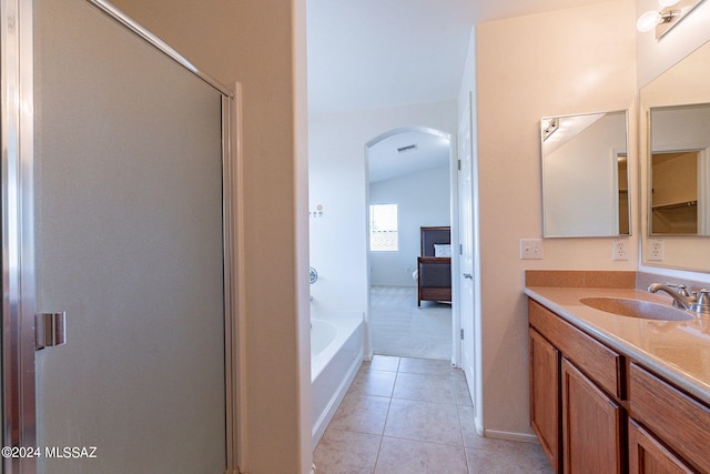 bathroom with plus walk in shower, vanity, tile patterned floors, and vaulted ceiling