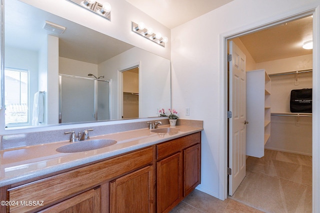 bathroom featuring tile patterned flooring, vanity, and an enclosed shower