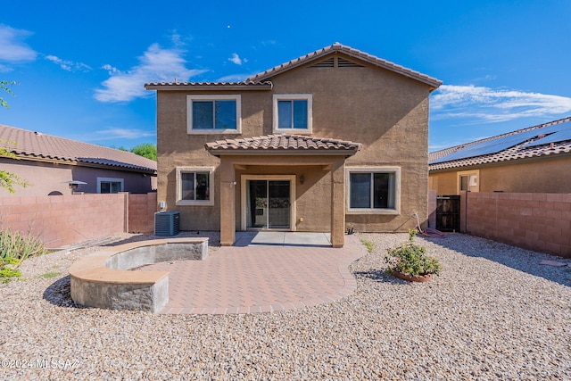 rear view of house featuring central AC unit and a patio