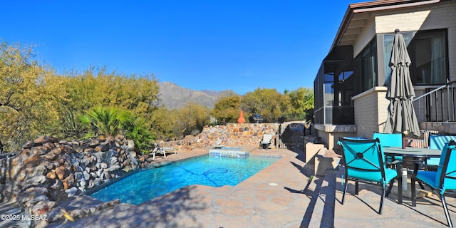 view of swimming pool with a mountain view and a patio