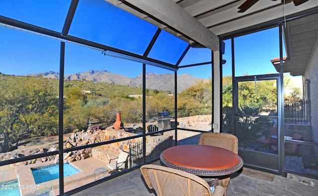 sunroom / solarium with a mountain view and ceiling fan