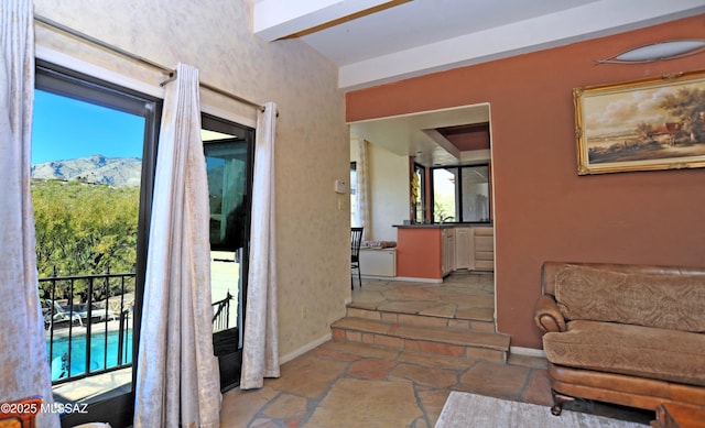 corridor with a mountain view and beamed ceiling